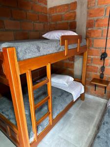 two bunk beds in a room with a brick wall at HOTEL EMBRUJO CAMPESTRE in Jardin