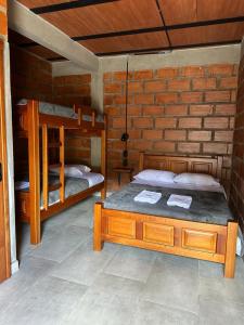 a bedroom with two bunk beds in a brick wall at HOTEL EMBRUJO CAMPESTRE in Jardin