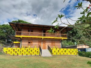 una casa con una valla amarilla delante de ella en HOTEL EMBRUJO CAMPESTRE, en Jardín