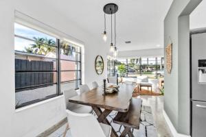 a dining room with a table and white chairs at Modern Pool Home Great for Families in Hollywood