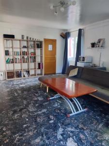 ein Wohnzimmer mit einem Tisch und einem Sofa in der Unterkunft Suite privée in Montélimar