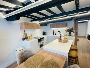 a kitchen with white cabinets and a table and chairs at Apartamento Magdalena 2 in Oviedo