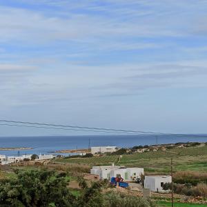 vistas a una playa con edificios y al océano en Isalos Paros, en Naousa