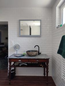 a bathroom with a sink and a mirror on a table at Suite privée in Montélimar