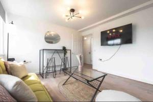 - un salon avec un canapé jaune et une table en verre dans l'établissement Exquisite Luxury Retreat, à Southampton