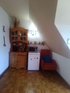a kitchen with a staircase with a stove and a chair at Ático en pleno pirineo in El Pueyo de Jaca