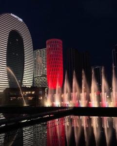 a water fountain in front of a city at night at Black Sea Vi Dari Apartments in Batumi