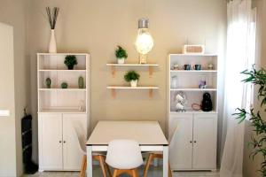 een eetkamer met een tafel en witte planken bij APARTAMENTO HUERTA LA REINA in Córdoba