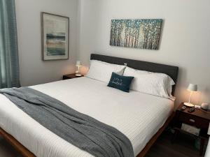um quarto com uma grande cama branca com duas mesas de cabeceira em New Centennial Park Luxury Smart Home w Courtyard em Fayetteville