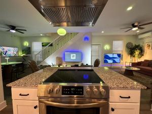 a kitchen with a stove and a living room at New Centennial Park Luxury Smart Home w Courtyard in Fayetteville