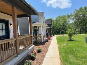 uma casa com um alpendre e uma passagem em New Centennial Park Luxury Smart Home w Courtyard em Fayetteville