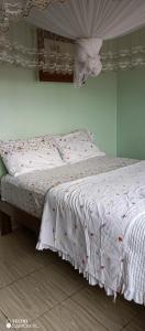 a bed with a white bedspread with cherries on it at Puma Garden and Suites - Nyarutarama in Kigali