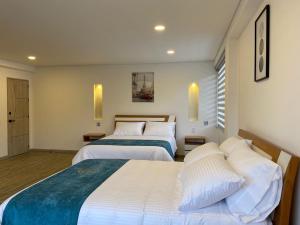 a hotel room with two beds and a window at HOTEL ISIS CONFORT in La Mesa