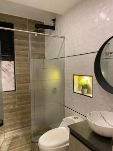 a bathroom with a toilet and a glass shower at HOTEL ISIS CONFORT in La Mesa