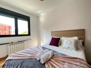 1 dormitorio con cama con almohadas y ventana en Luminoso Madrid Javalambre, en Madrid