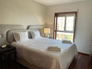 a bedroom with a large white bed with a window at Home of Neptune in Póvoa de Varzim