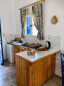 cocina con encimera de madera y ventana en Kastri Apartments, en Emborios