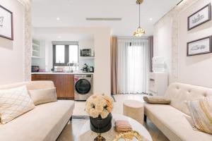 T Place Luxury Apartment Hoan Kiem Lake by SSens Homes في هانوي: غرفة معيشة مع كنبتين ومطبخ