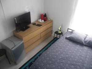 1 dormitorio con 1 cama y vestidor con TV en Charmant F2 de 30m2 moin cher à 25 min de Paris jusqu'à 5 personnes, en Le Mée-sur-Seine