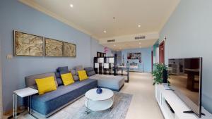 sala de estar con sofá azul y almohadas amarillas en Marina Heights - Unique One Bedroom, en Dubái