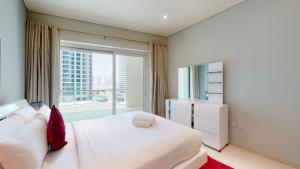 Un dormitorio con una cama blanca y una ventana grande. en Marina Heights - Unique One Bedroom, en Dubái