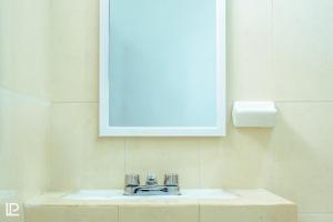 lavabo con espejo y lavabo en Hotel Quiam en Playa del Carmen
