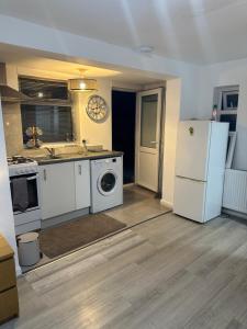 een keuken met een koelkast, een wasmachine en een droger bij Stylish Studio flat - Watford Junction - Harry potter in Watford