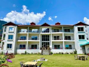 KalāmMaria Hotel and Resorts的一座带桌椅的大型白色建筑