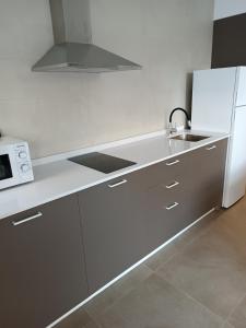 a white kitchen with a sink and a refrigerator at APARTAMENTOS Posada Del Mar in Los Mártires