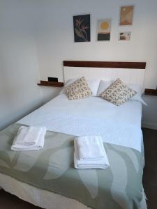 a white bed with two towels on it at APARTAMENTOS Posada Del Mar in Los Mártires