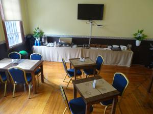 comedor con mesas y sillas y mesa con mesa en Gran Casona Hostal, en Iquique