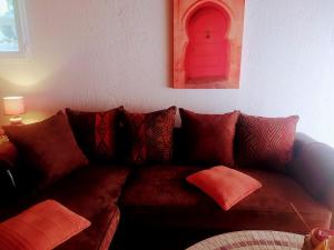 DionsにあるLes Gîtes De Cayenne - Gîte ORIENTのリビングルーム(ブラウンソファ、オレンジの枕付)