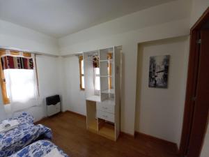 1 dormitorio con cama, tocador y espejo en hostel comunidad Ushuaia en Ushuaia