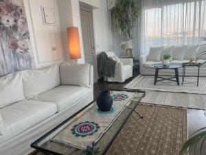 La Perle Pyramids في القاهرة: غرفة معيشة مع أريكة بيضاء وطاولة