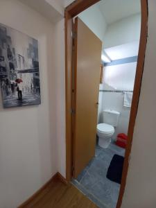 a bathroom with a toilet and a door open at hostel comunidad Ushuaia in Ushuaia