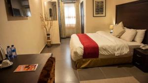 a hotel room with a bed and a table at SSNIT GUEST HOUSE in Nima