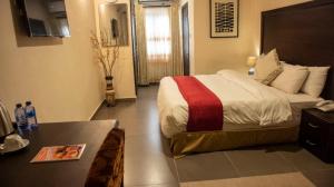 NimaにあるSSNIT GUEST HOUSEのベッドとテーブルのあるホテルの部屋