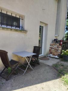 einen Tisch und zwei Stühle vor einem Gebäude in der Unterkunft Suite privée in Montélimar
