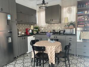 a kitchen with a table with chairs and a table and a kitchen at La Perle Pyramids in Cairo