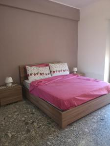 um quarto com uma cama grande com lençóis e almofadas cor-de-rosa em Malatesta House em Roma