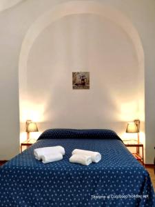 1 dormitorio con 1 cama azul y 2 toallas en Teatime al Colosseo, en Roma