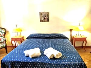 1 dormitorio con 1 cama azul y 2 toallas en Teatime al Colosseo, en Roma