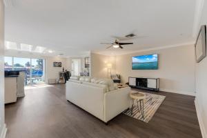 un soggiorno con divano bianco e ventilatore a soffitto di Gulf Access, Kayaks, PET Friendly - Escape to Versailles - Roelens Vacations a Cape Coral