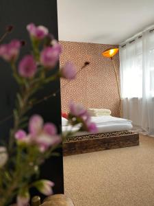 1 dormitorio con 1 cama, espejo y flores en PrivArtZimmer 'Ausfahrt freihalten', en Husum