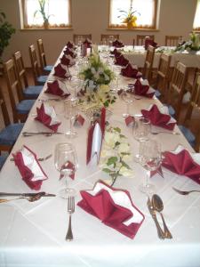 einen langen Tisch mit roten Servietten und Weingläsern in der Unterkunft Landgasthof Sepplwirt in Kindberg