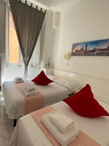 a bedroom with two beds and a painting on the wall at GUEST HOUSE FIDARDO in Rome