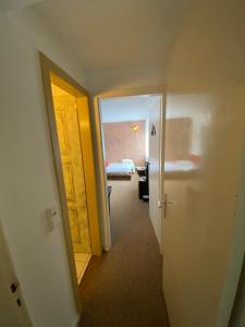 a hallway with a room with a bed and a door at PrivArtZimmer 'Ausfahrt freihalten' in Husum