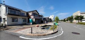 una calle de ciudad vacía con casas al lado en CANAL HOUSE BOSTONS, en Niigata