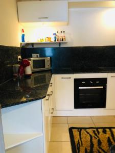 a kitchen with white cabinets and a black counter top at Chambre d'Hôtes Palm Marina du Gosier in Le Gosier