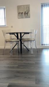 uma mesa de jantar com cadeiras e uma foto na parede em Luxury apartment in dudley em West Bromwich